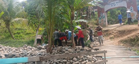 Masyarakat menggendong batu ke titik pembuatan bro